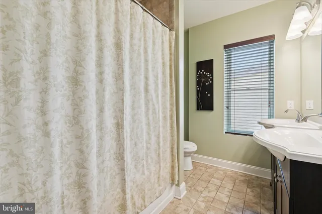 a bathroom with a sink a toilet and shower curtain