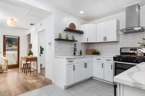 a kitchen with stainless steel appliances a stove a sink a refrigerator and cabinets