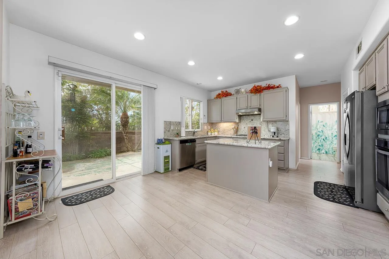 1559 Pleasanton Road Chula Vista, CA 91913 - Photo 6 of 41 a kitchen with a refrigerator and white cabinets