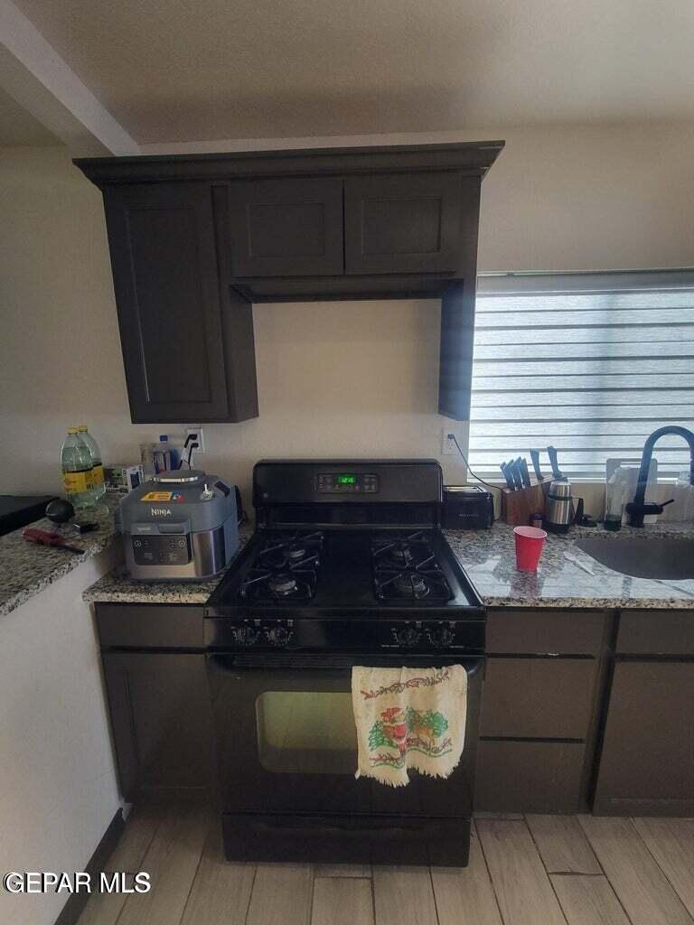 11531 Ernest Road, Unit 13 Socorro, TX 79927 - Photo 17 of 36 a kitchen with stainless steel appliances granite countertop a stove a sink and a microwave