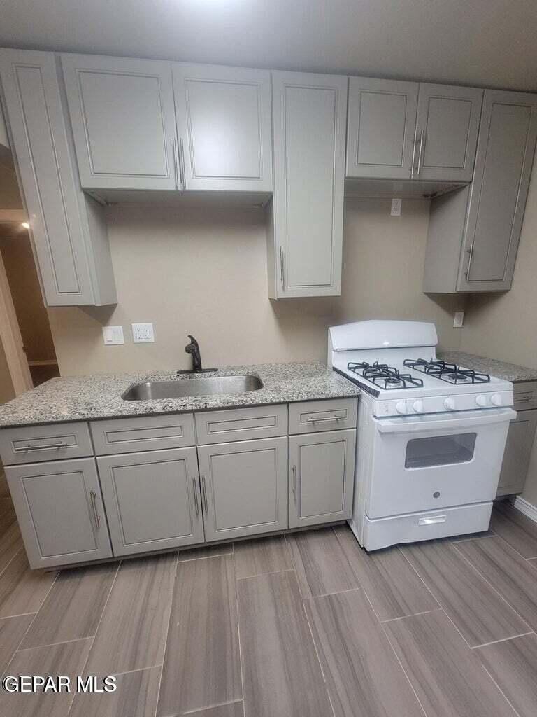 11531 Ernest Road, Unit 13 Socorro, TX 79927 - Photo 7 of 36 a kitchen with granite countertop white cabinets and white stainless steel appliances