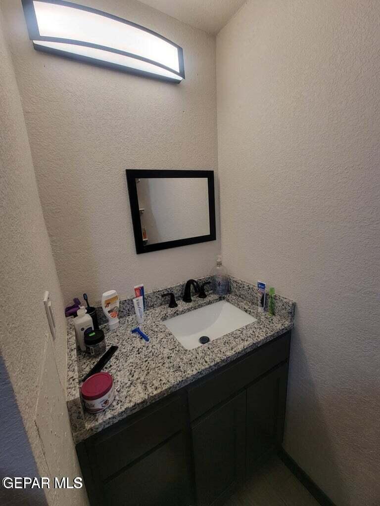11531 Ernest Road, Unit 13 Socorro, TX 79927 - Photo 8 of 36 a bathroom with a granite countertop sink and a mirror