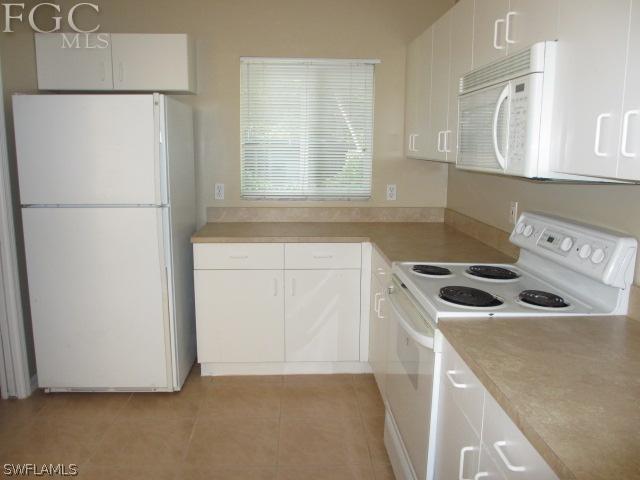 17421 Lee Road Fort Myers, FL 33967 - Photo 5 of 13 a kitchen with a refrigerator sink stove and cabinets