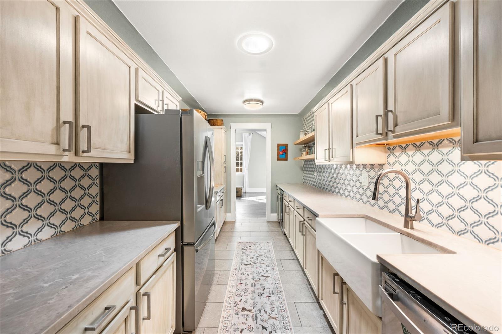 4730 Otis Street Wheat Ridge, CO 80033 - Photo 13 of 34 a kitchen with granite countertop a sink stove refrigerator and cabinets