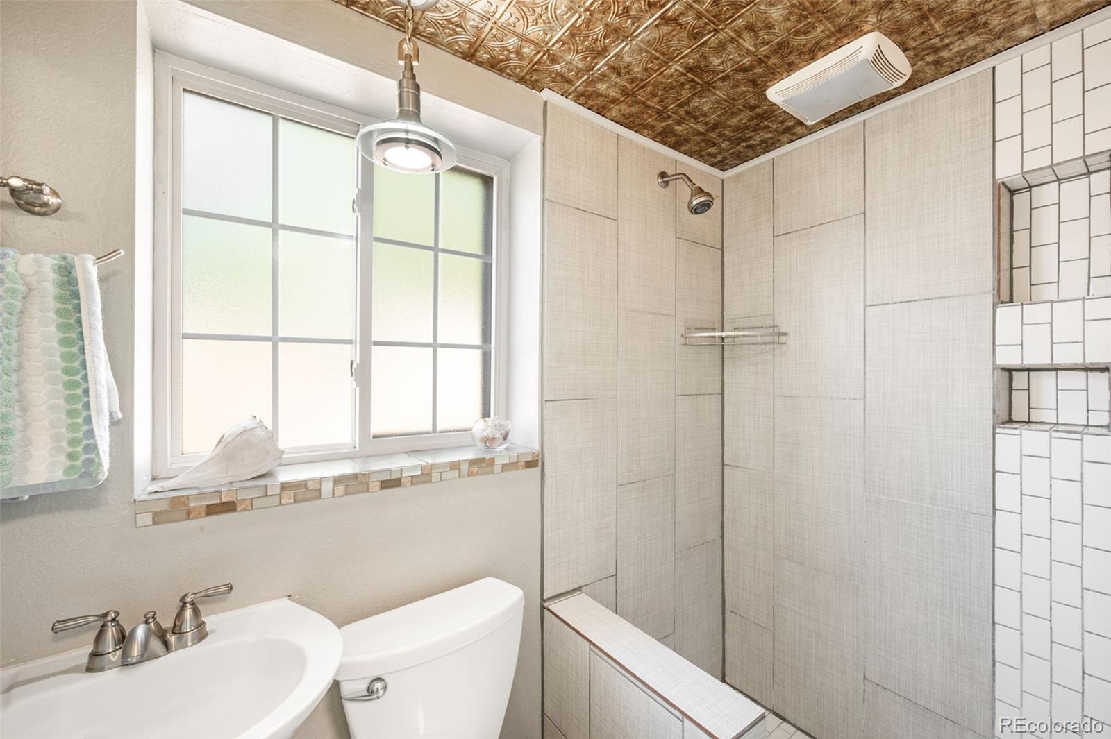 4730 Otis Street Wheat Ridge, CO 80033 - Photo 17 of 34 a bathroom with a sink toilet a mirror and shower