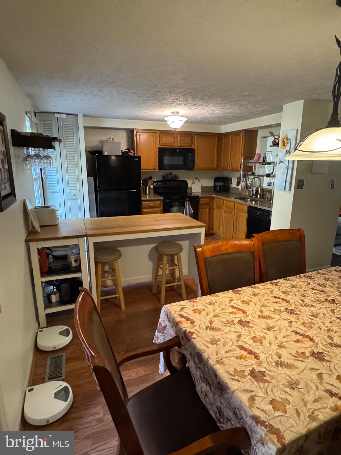 1565 Autumn Ridge Circle Reston, VA 20194 - Photo 6 of 19 a kitchen with stainless steel appliances kitchen island granite countertop a sink dishwasher a stove a refrigerator a microwave oven with cabinets and wooden floor