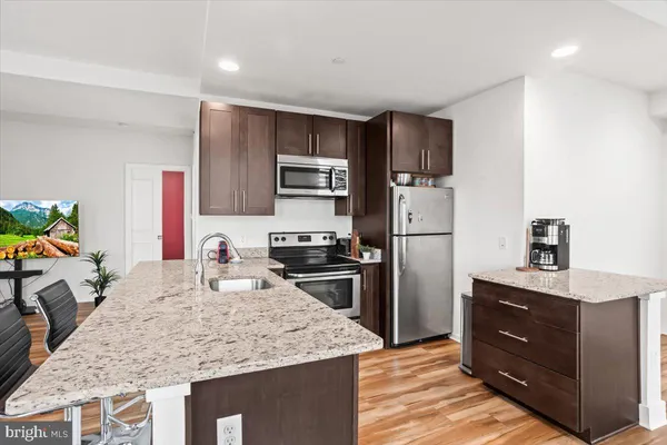 a kitchen with stainless steel appliances granite countertop a sink stove and refrigerator