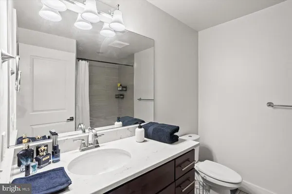 a bathroom with a sink vanity mirror and toilet