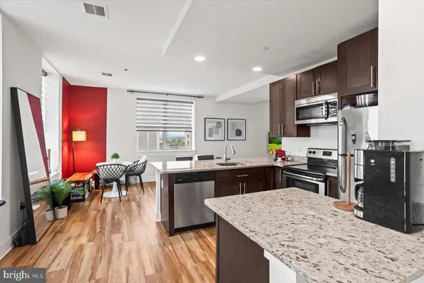 a kitchen with stainless steel appliances granite countertop sink stove top oven and cabinets