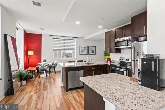 a kitchen with stainless steel appliances granite countertop sink stove top oven and cabinets