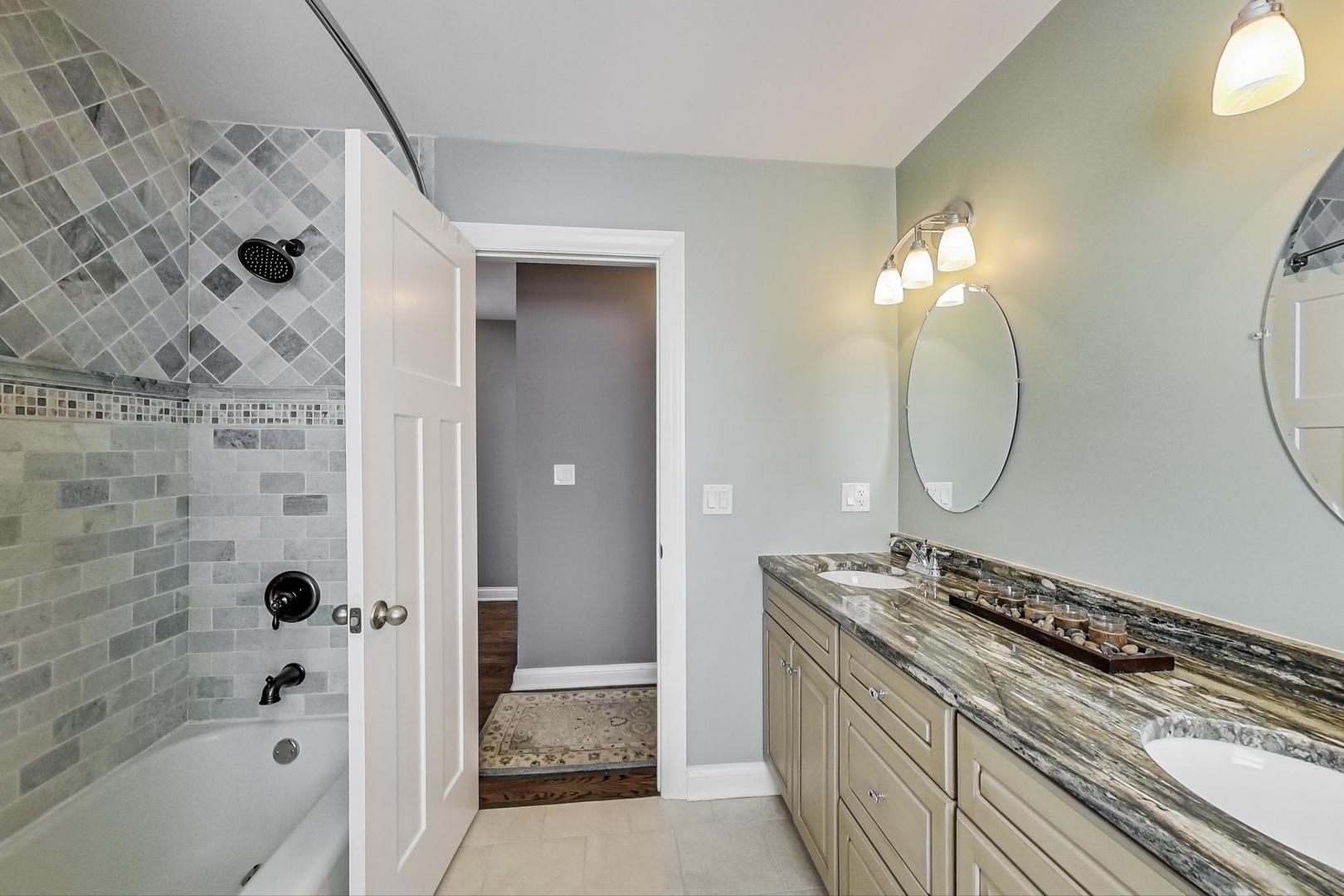 1526 West Talcott Road Park Ridge, IL 60068 - Photo 11 of 24 a bathroom with a granite countertop sink a toilet and shower