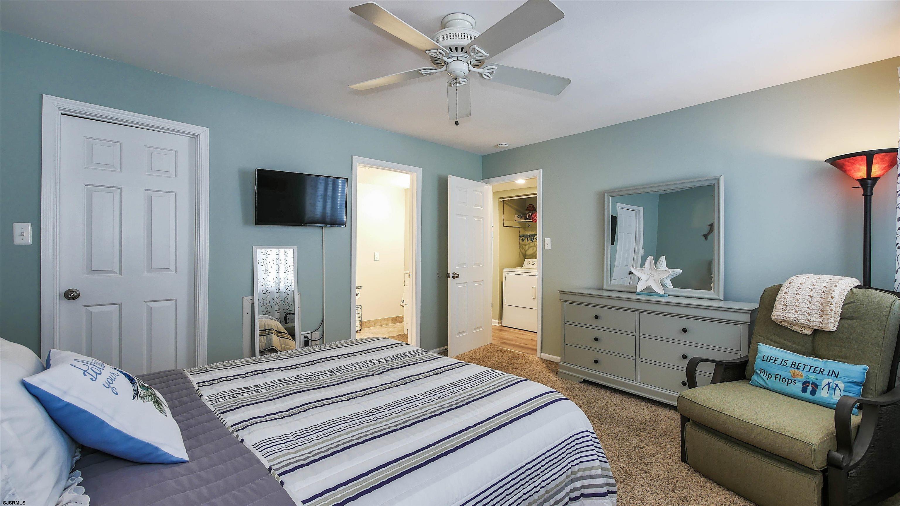 4318 West Brigantine Avenue, Unit D1 Brigantine, NJ 08203 - Photo 13 of 30 a spacious bedroom with a bed and a chandelier