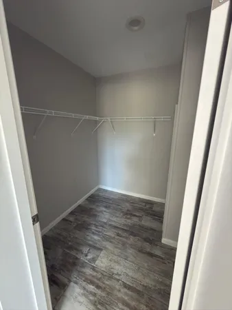 an empty room with wooden floor and door