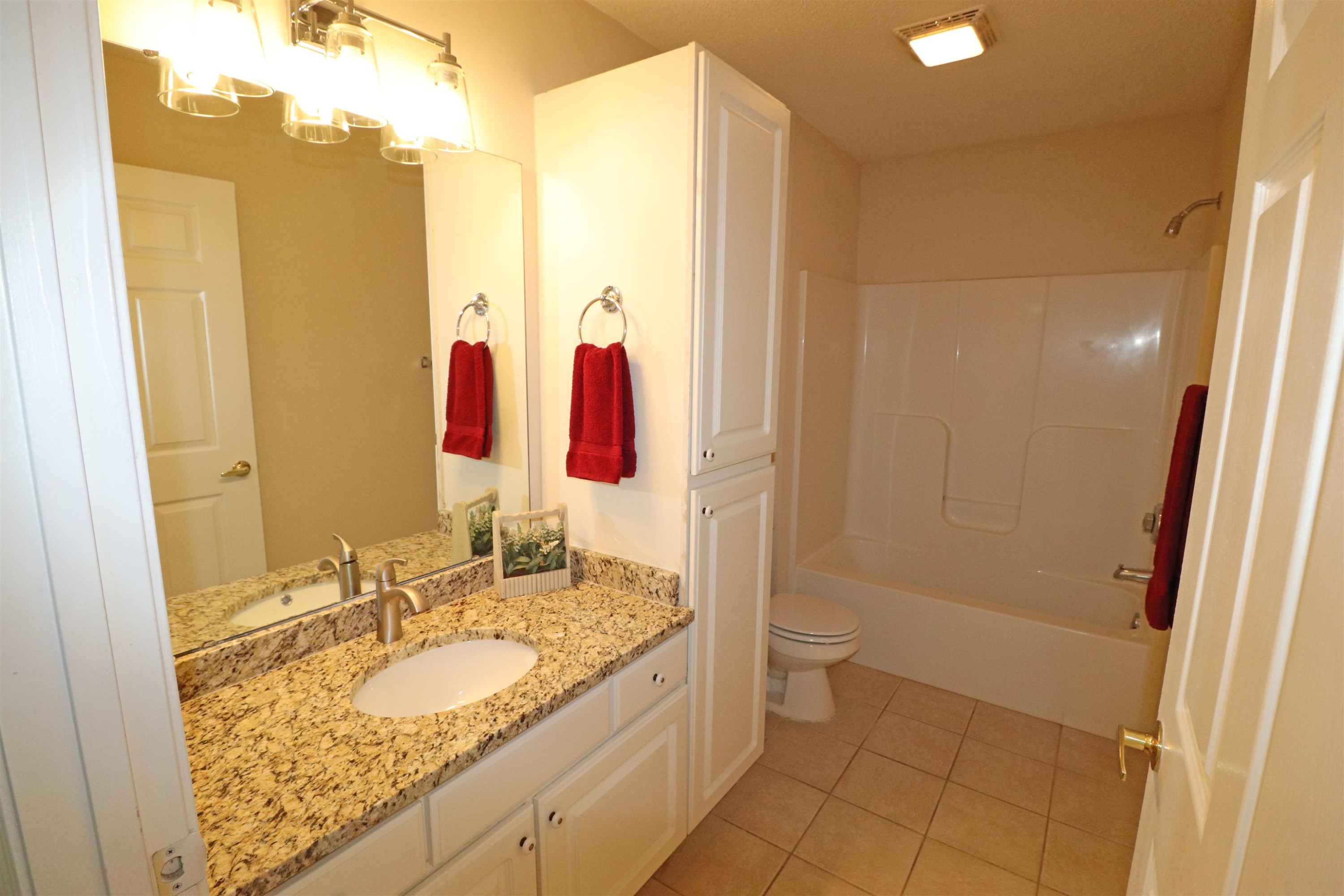 11371 Involute Place, Unit 103 Raleigh, NC 27617 - Photo 22 of 34 a bathroom with a granite countertop sink and a mirror