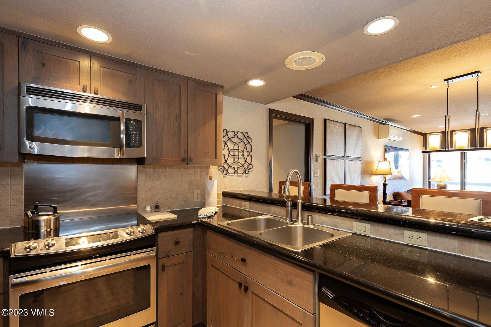 210 Offerson Road, Unit 209 WEEK 30 Beaver Creek, CO 81620 - Photo 10 of 27 a kitchen with stainless steel appliances a sink a stove and a microwave