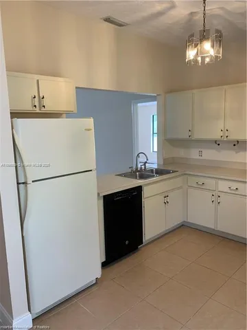 a kitchen with a sink a refrigerator and cabinets