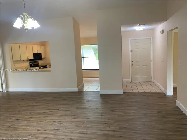 a view of a room with wooden floor and a flat screen tv