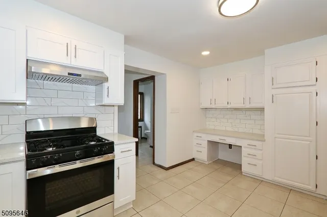 a kitchen with white cabinets and appliances
