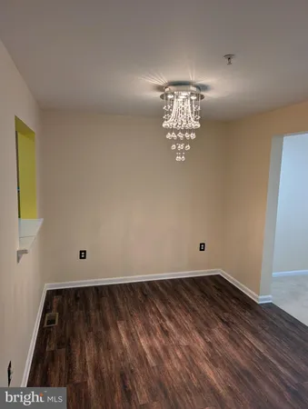 a view of a hallway with wooden floor and closet