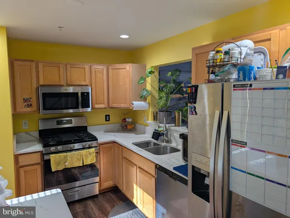a kitchen with stainless steel appliances a stove a sink and a refrigerator