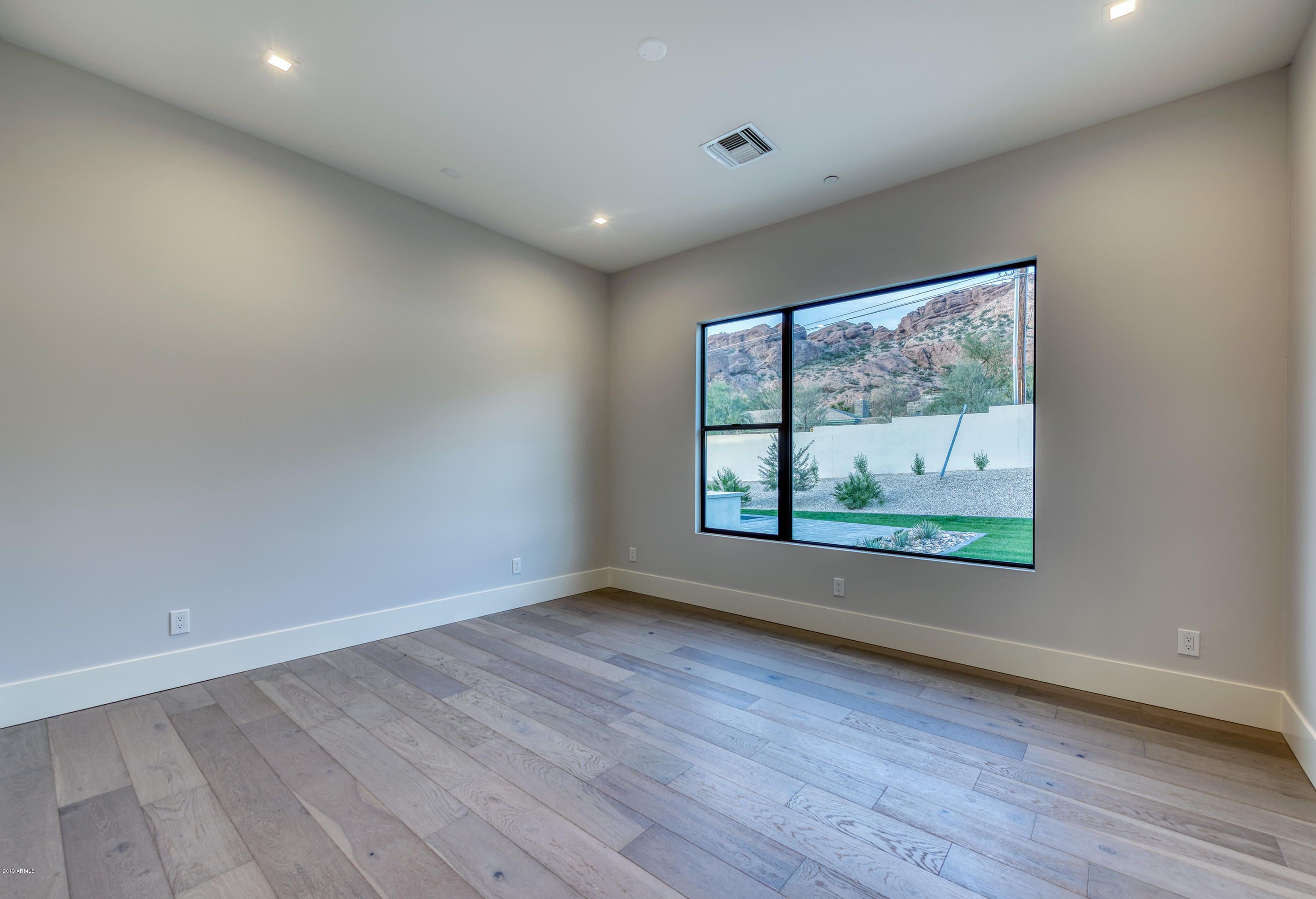 4822 East Palomino Road Phoenix, AZ 85018 - Photo 53 of 80 an empty room with wooden floor and windows
