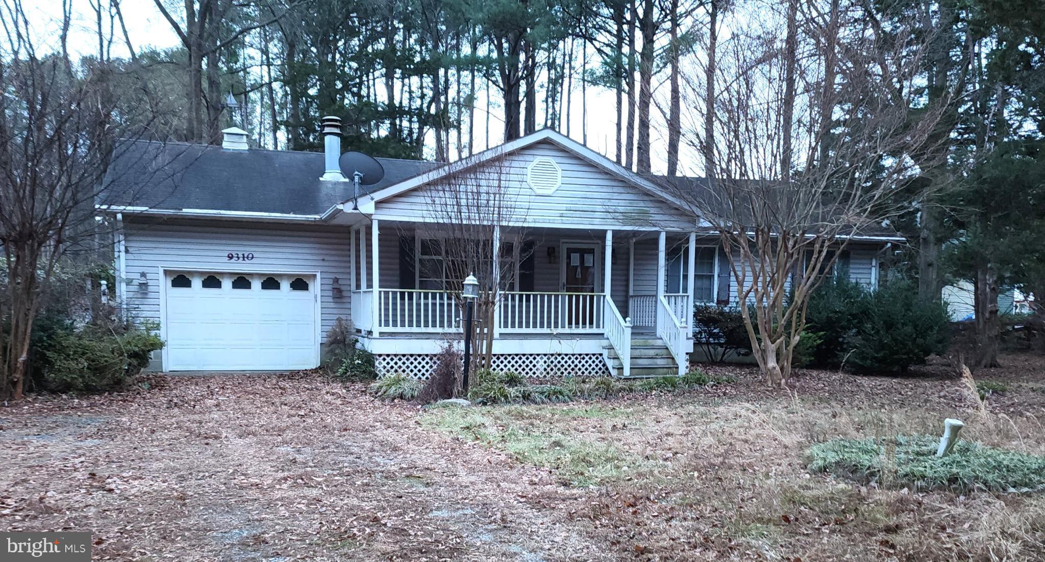 a view of a house with a yard and large tree