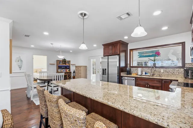 a kitchen with stainless steel appliances granite countertop a refrigerator and a sink