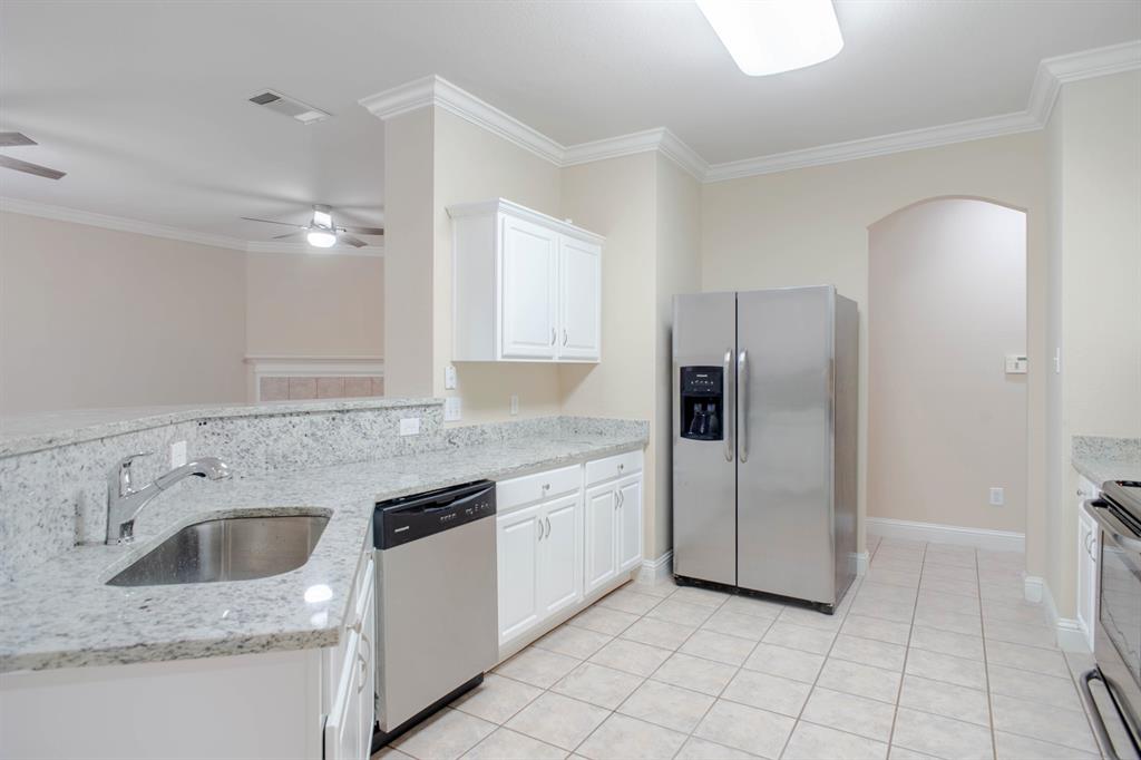 4929 Spur Ridge Court Fort Worth, TX 76244 - Photo 14 of 34 a kitchen with stainless steel appliances granite countertop a sink stove and refrigerator