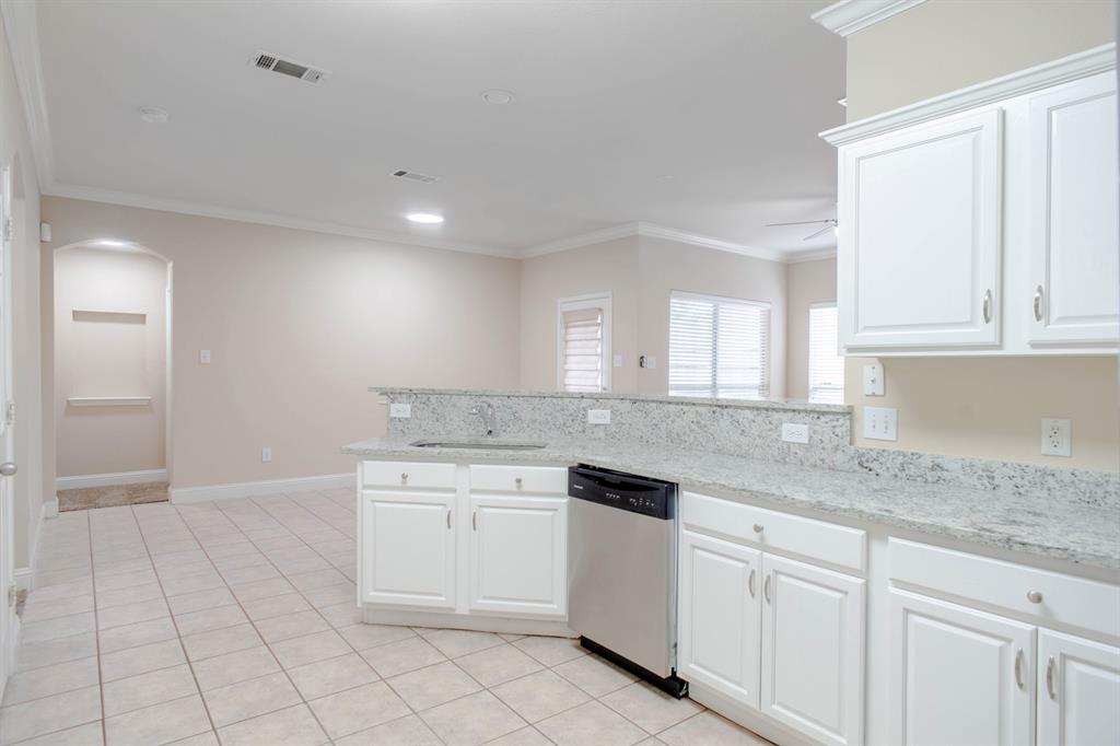 4929 Spur Ridge Court Fort Worth, TX 76244 - Photo 16 of 34 a kitchen with white cabinets appliances a sink and a counter space
