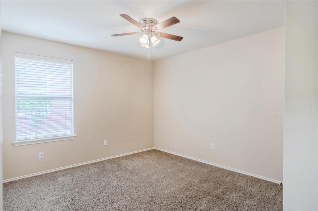 4929 Spur Ridge Court Fort Worth, TX 76244 - Photo 25 of 34 an empty room with a window and a ceiling fan