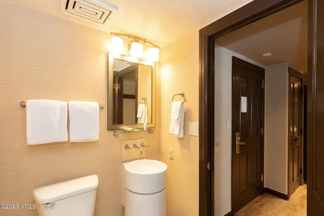 a bathroom with a toilet a sink and mirror