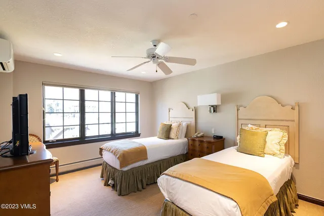 a bedroom with two beds and a chandelier