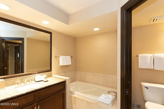a bathroom with a granite countertop sink a toilet and shower