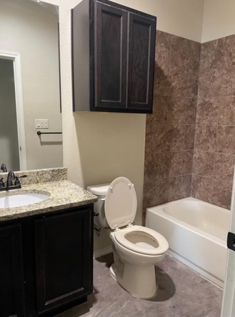 601 Jack Rabbit Lane, Unit B Buda, TX 78610 - Photo 6 of 10 a bathroom with a granite countertop toilet sink and mirror