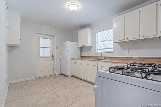 a kitchen with cabinets appliances a sink and a window