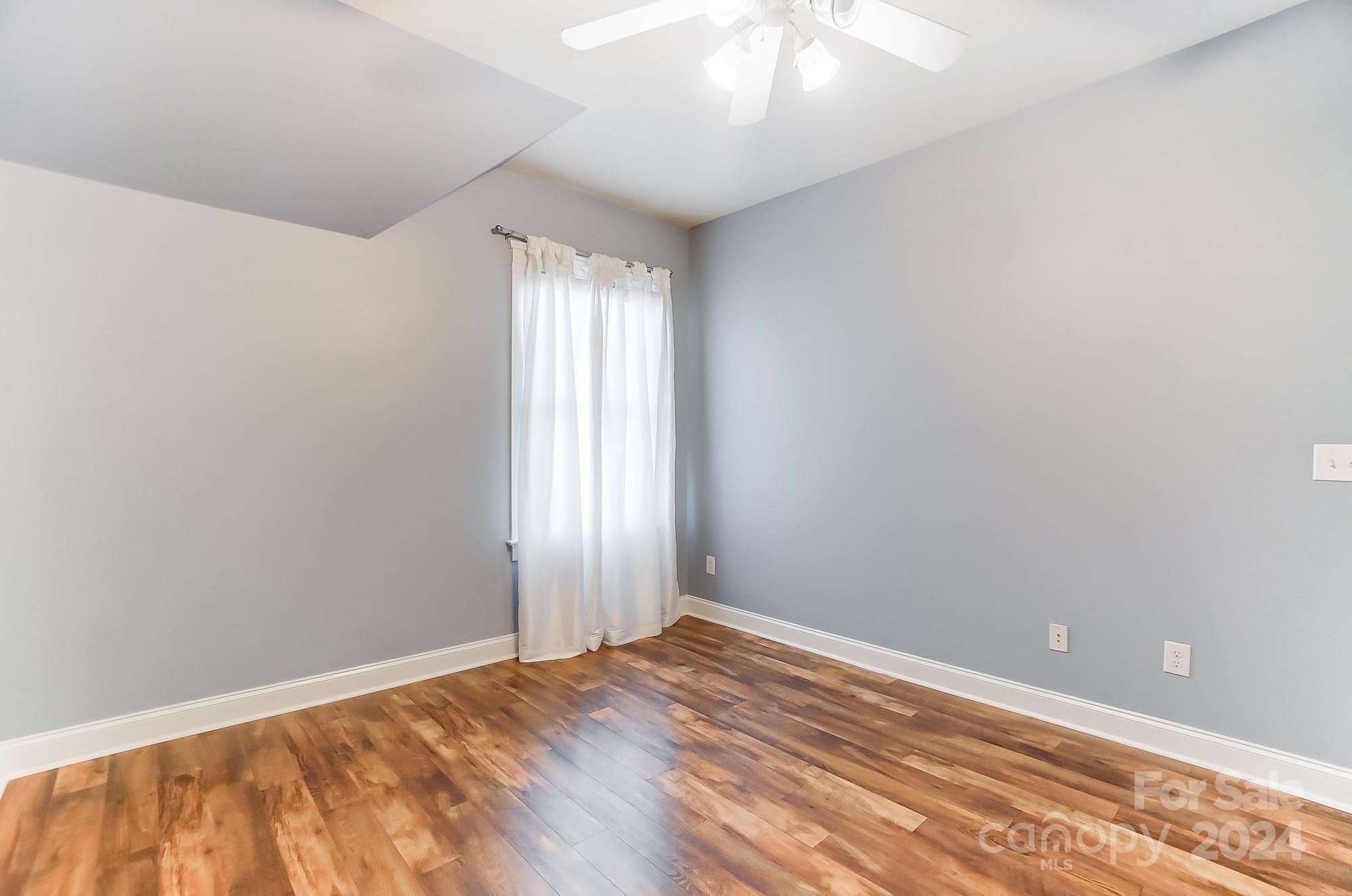 169 Mills Lane Fort Mill, SC 29708 - Photo 27 of 38 an empty room with wooden floor and windows