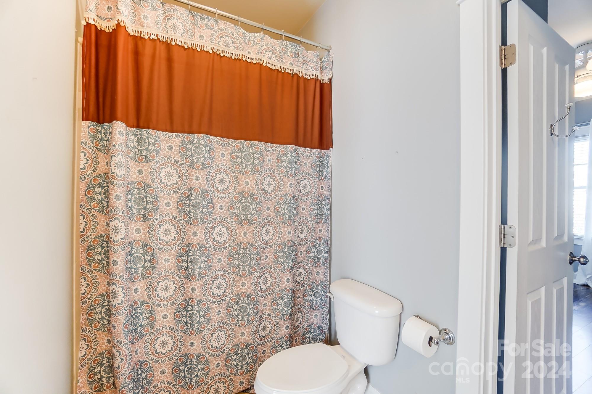 169 Mills Lane Fort Mill, SC 29708 - Photo 31 of 38 a bathroom with a toilet and a shower curtain