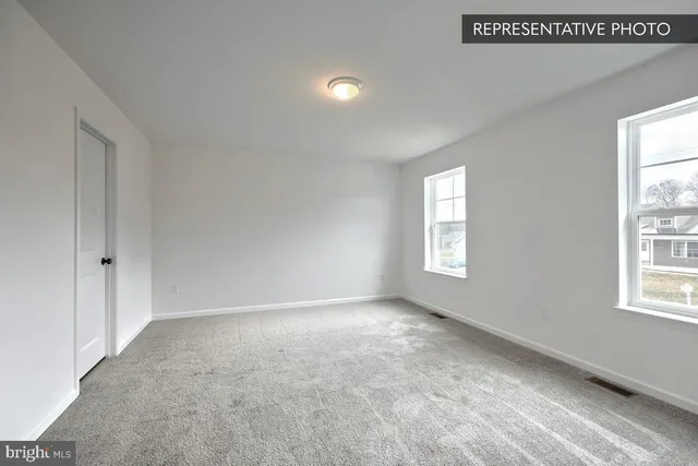 an empty room with windows and closet