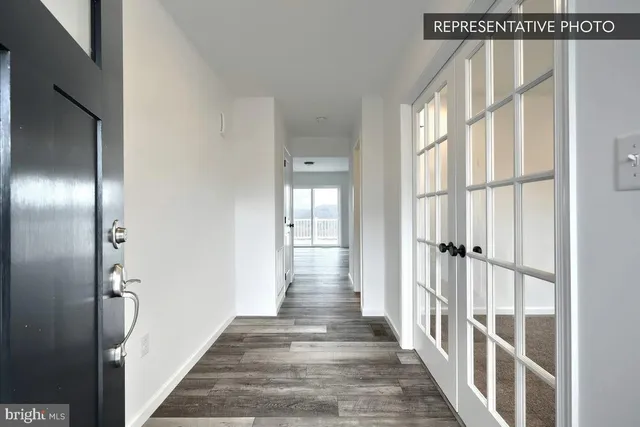 a view of a hallway with wooden floor and windows