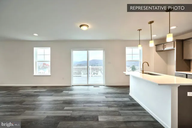 a view of a kitchen with kitchen island a sink wooden floor and a large window