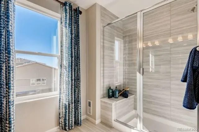a bathroom with a granite countertop sink a mirror and a shower