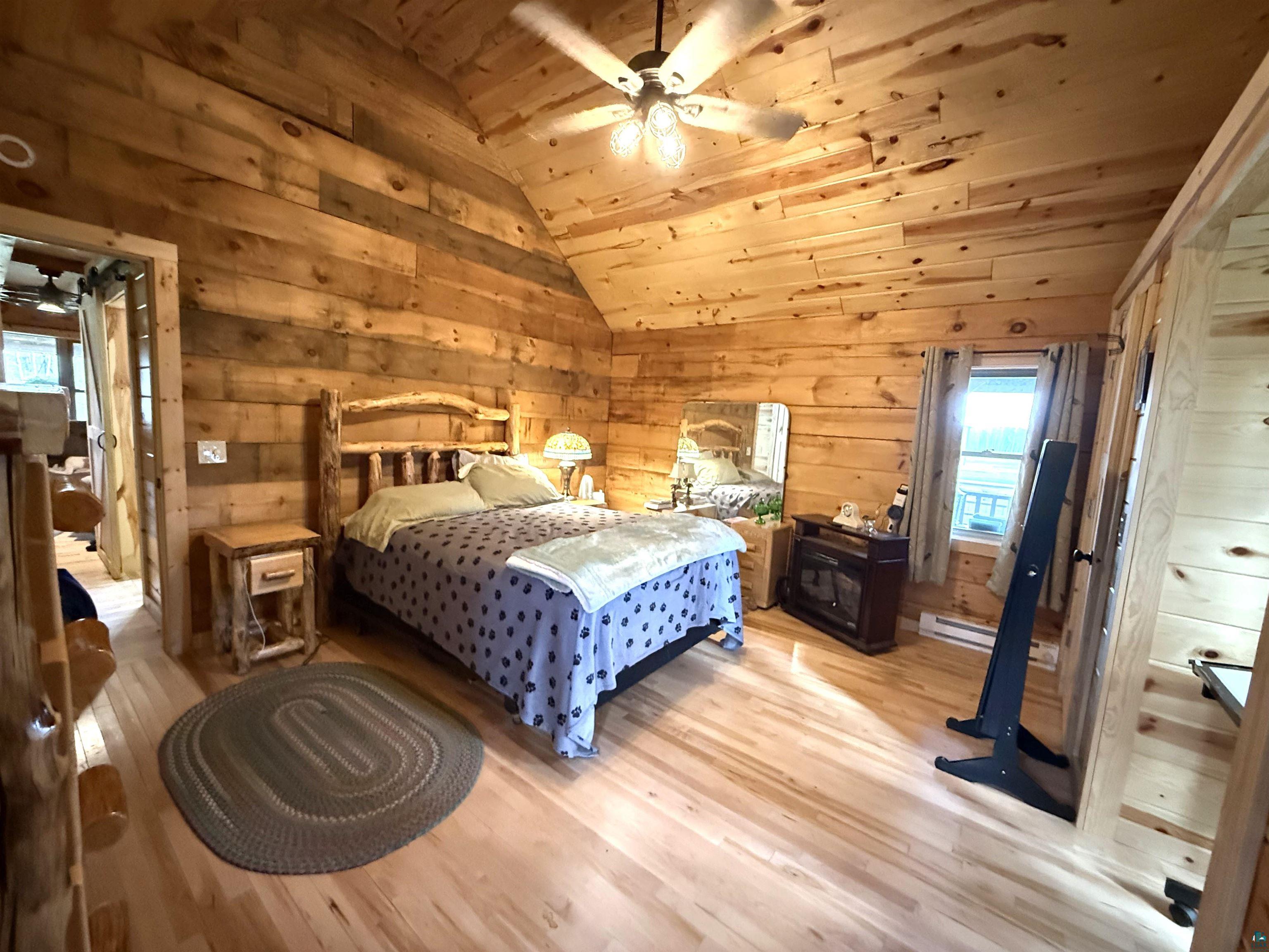 37590 Degerstrom Road Askov, MN 55704 - Photo 15 of 53 Room featuring extensive wood-finish wall and ceiling paneling, sloped ceilings, and wood-finish flooring