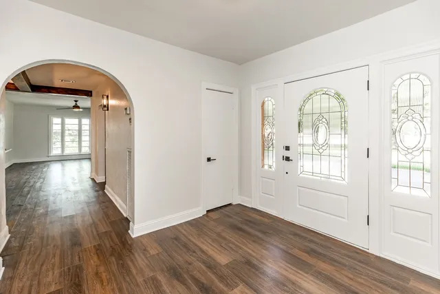 a view of a livingroom with wooden floor and windows