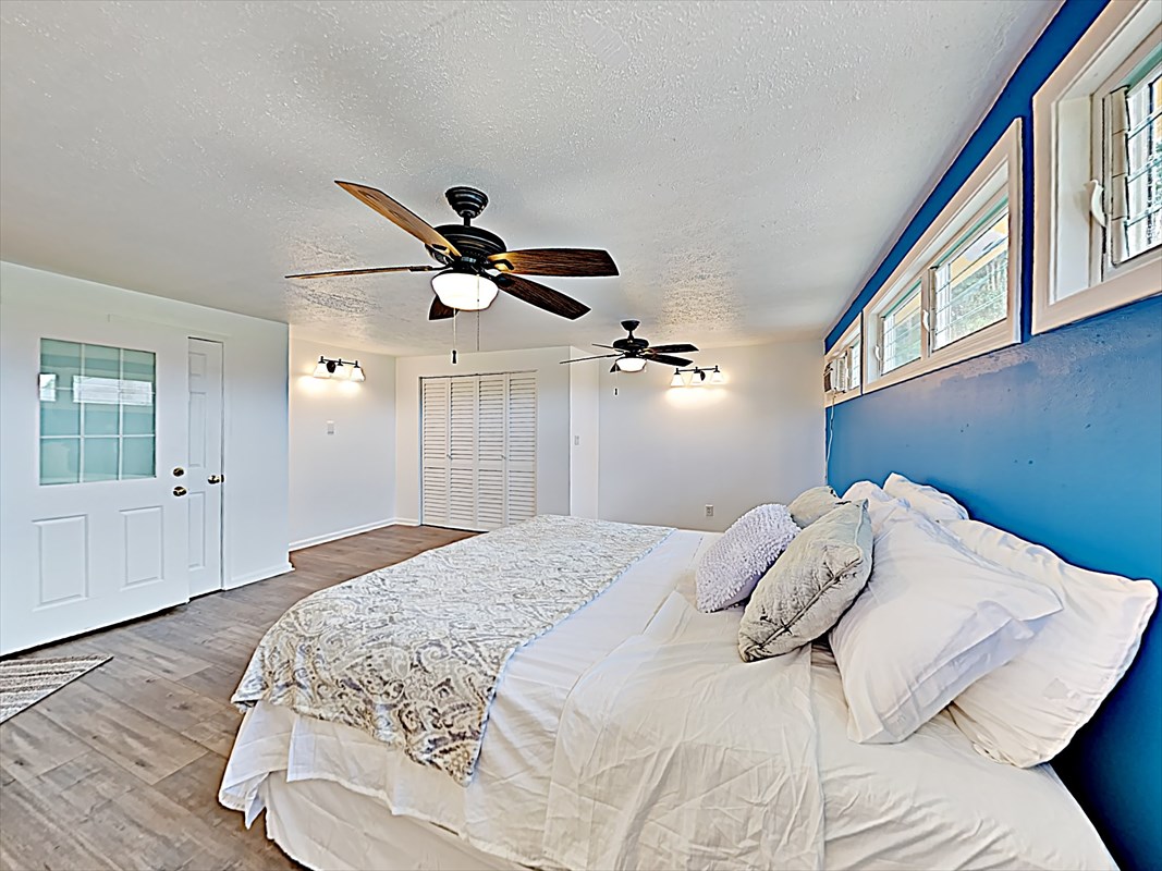 4911 Nonou Road Kapaa, HI 96746 - Photo 15 of 21 a bedroom with a bed and a chandelier