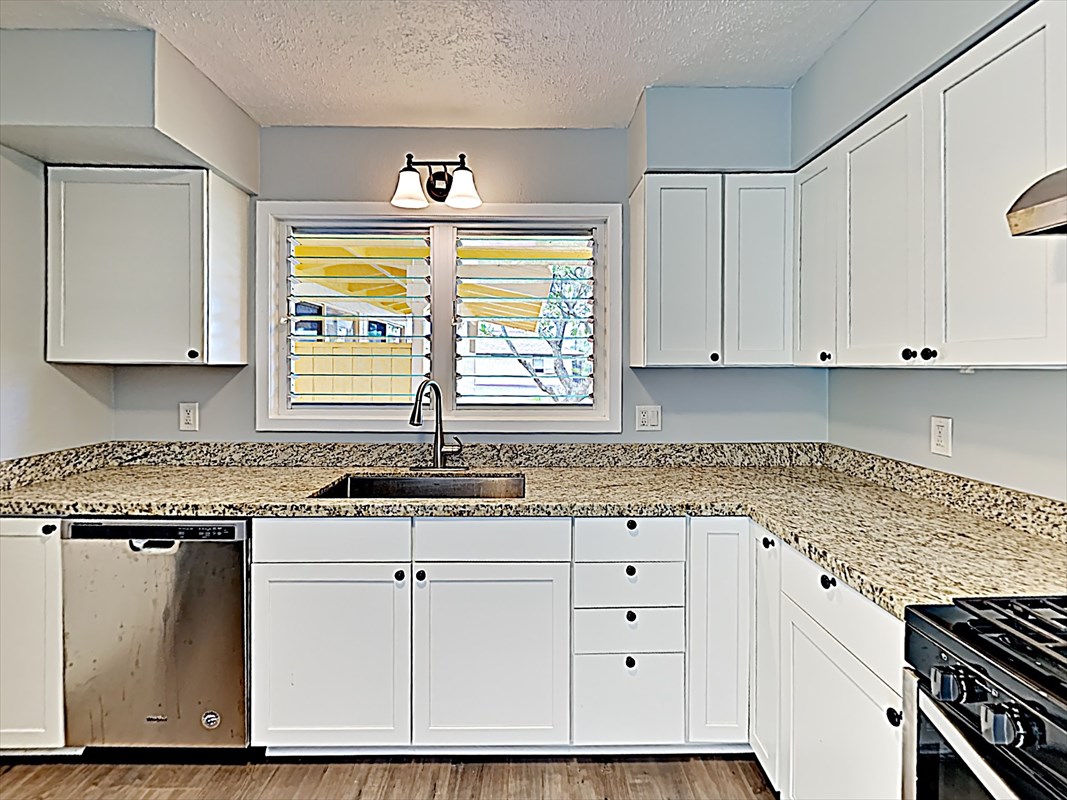 4911 Nonou Road Kapaa, HI 96746 - Photo 3 of 21 a kitchen with granite countertop white cabinets and white appliances
