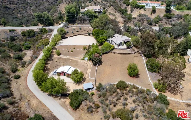 an aerial view of a house with a yard and large trees