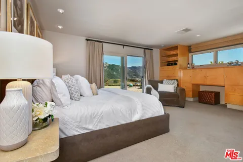 a view of a house with a yard and a large tree