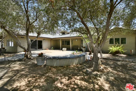 a backyard of a house with table and chairs