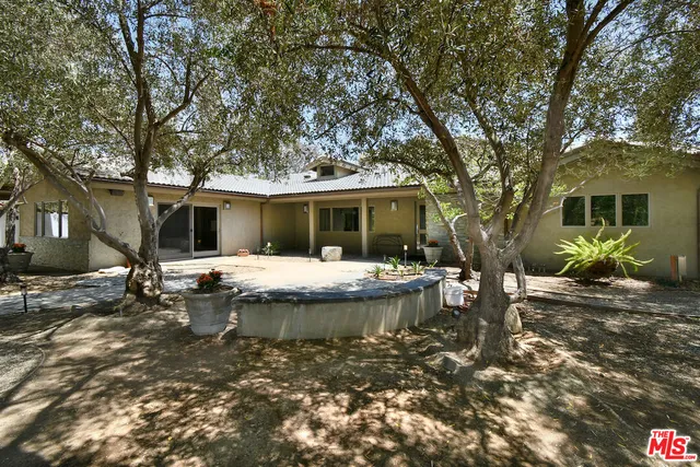 a backyard of a house with table and chairs
