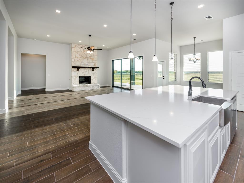 2108 Charters Circle Nevada, TX 75173 - Photo 36 of 37 Kitchen featuring a fireplace, a large island with sink, recessed lighting, wood tiled floors, and open floor plan